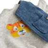 A close-up view of a child's clothing set featuring a tiger graphic. Produktbild-Vorschau