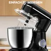 A close-up shot of a black stand mixer with a whisk attachment and a clear splash guard, set in a kitchen environment. Produktbild-Vorschau
