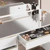 A close-up view of a white vanity table with gold accents, showing an open drawer filled with makeup and accessories. Produktbild-Vorschau