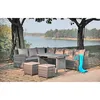 An outdoor lounge set with a table and seating is placed near a body of water under trees. Produktbild-Vorschau
