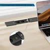 A black built-in power strip with two outlets and USB ports is installed on a wooden desk, with a laptop connected to it. Produktbild-Vorschau