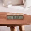 A close-up shot of a flip clock on a wooden table, with a blurred background of a bed. Anteprima dell’immagine prodotto