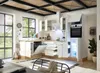 A modern, well-lit kitchen with white cabinets, wooden countertops, and a large window. Produktbild-Vorschau