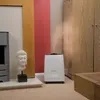 A white humidifier is shown in a room with a Buddha statue and wooden furniture. Produktbild-Vorschau