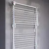 A white wall-mounted drying rack is shown mounted on a textured gray wall. Produktbild-Vorschau