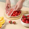 Hands covering a bowl of cherry tomatoes with a plastic wrap. Produktbild-Vorschau