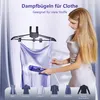 A woman is steaming a dress, with various clothing items displayed below. Produktbild-Vorschau