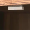 A close-up view of a small gray rectangular object attached to the underside of a wooden surface. Produktbild-Vorschau