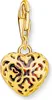 A gold heart-shaped charm with intricate filigree and a red stone inside, suspended from a clasp. Náhled obrázku produktu