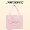 A pink gift box with a marble pattern and pink ribbon handles, with the brand logo above. Náhled obrázku produktu