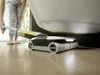 A person is using a cordless floor cleaner under a toilet. Produktbild-Vorschau