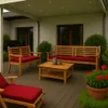 An outdoor patio with wooden furniture and red cushions, set against a house. Produktbild-Vorschau