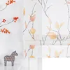 A close-up view of a window blind with a pattern of branches and leaves, next to a decorative horse figurine. Produktbild-Vorschau