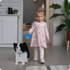 A young girl is walking with a plush dog on a leash indoors. Anteprima dell’immagine prodotto