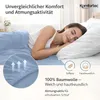 A woman sleeping peacefully in a bed with light blue bedding. Produktbild-Vorschau