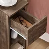 A close-up view of an open drawer in a wooden nightstand, revealing a pair of glasses and a white headphone on a shelf below. Anteprima dell’immagine prodotto