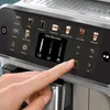 A close-up of a coffee machine's touch screen interface with a hand interacting with it. Produktbild-Vorschau