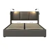 A modern gray upholstered bed frame with a slatted base and two integrated reading lights on the headboard, presented against a white background. Náhled obrázku produktu