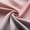 A close-up of folded pink and gray fabric with a textured pattern. Náhled obrázku produktu