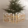 A wooden fence with white accents and small decorative birdhouses, decorated with small LED lights, is placed around the base of a Christmas tree. Náhled obrázku produktu