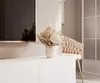 A modern living room setting with a TV stand, a bouquet of dried flowers, and a chair. Produktbild-Vorschau