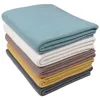 A stack of folded blankets in various colors. Produktbild-Vorschau