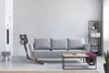 A modern living room with a gray sofa, coffee table, and a cordless vacuum cleaner. Voir les images du produit