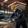 A worker in a factory setting is using an angle grinder to cut metal, creating sparks. Náhľad obrázku produktu