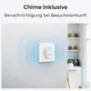 A white smart chime device plugged into a wall outlet, with blue concentric circles indicating its signal range. A blurred kitchen background is visible on the right. Produktbild-Vorschau