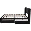 A side view of a black upholstered bed frame with wooden slats and two open drawers underneath. Produktbild-Vorschau