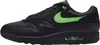 A side view of a black Nike Air Max 1 Essential sneaker with green accents. Produktbild-Vorschau