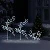Christmas decorations of illuminated reindeer and a sleigh in a snowy outdoor setting at night. Voir les images du produit