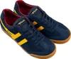 A pair of blue Gola Harrier sneakers with yellow stripes and red lining, shown from a slightly elevated side angle against a white background. Produktbild-Vorschau