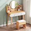 A wooden vanity table with a mirror and stool, decorated with various cosmetic items. Podgląd zdjęcia produktu