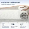 A person is rolling out a mattress topper on a bed. Produktbild-Vorschau