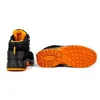 A black work boot with orange accents is shown from the back and sole view against a white background. Produktbild-Vorschau