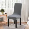A gray chair cover on a chair, placed in a room with sheer curtains in the background. Náhled obrázku produktu