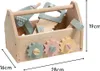 A wooden toy toolbox filled with various wooden tools and gears, with dimensions indicated by measurement lines. Produktbild-Vorschau