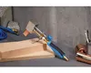 A soldering iron with a copper tip is placed on a wooden block, with hoses and other tools in the background. Anteprima dell’immagine prodotto
