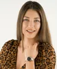 A woman wearing a watch and a leopard print top. Produktbild-Vorschau