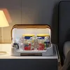 A baby bottle drying rack with bottles and jars inside, placed on a bedside table next to a lamp. Produktbild-Vorschau