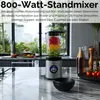 A kitchen counter with a blender filled with fruit, and some ingredients and bottles in the background. Produktbild-Vorschau