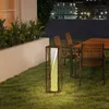 An outdoor patio scene at night with a table and chairs, illuminated by a stylish solar lantern. Podgląd zdjęcia produktu