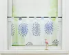 A short curtain with a blue floral pattern hangs in a window, with a small pink flamingo figurine on the windowsill.