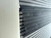 A close-up view of a striped roller blind, showing the texture and the way it is rolled up. Produktbild-Vorschau