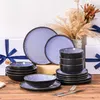 Das Geschirrset steht auf dem Tisch, umgeben von Geschenkboxen mit blauen Bändern, und Blumen. Voir les images du produit