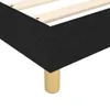 A close-up view of the corner of a black fabric boxspring bed frame with wooden slats and a single tan leg. Produktbild-Vorschau
