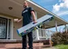 A man is standing on the steps of a house, holding a silver and blue work platform. Anteprima dell’immagine prodotto