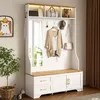 A hallway storage unit with a bench, mirror, and hooks, decorated with a plant and a framed picture of a cat. Produktbild-Vorschau