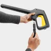 Hands connecting a hose to a pressure washer gun. Produktbild-Vorschau